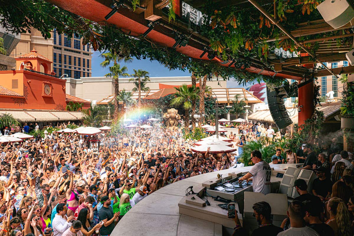A crowd of people surrounding the DJ booth at TAO Beach dancing to the music. 