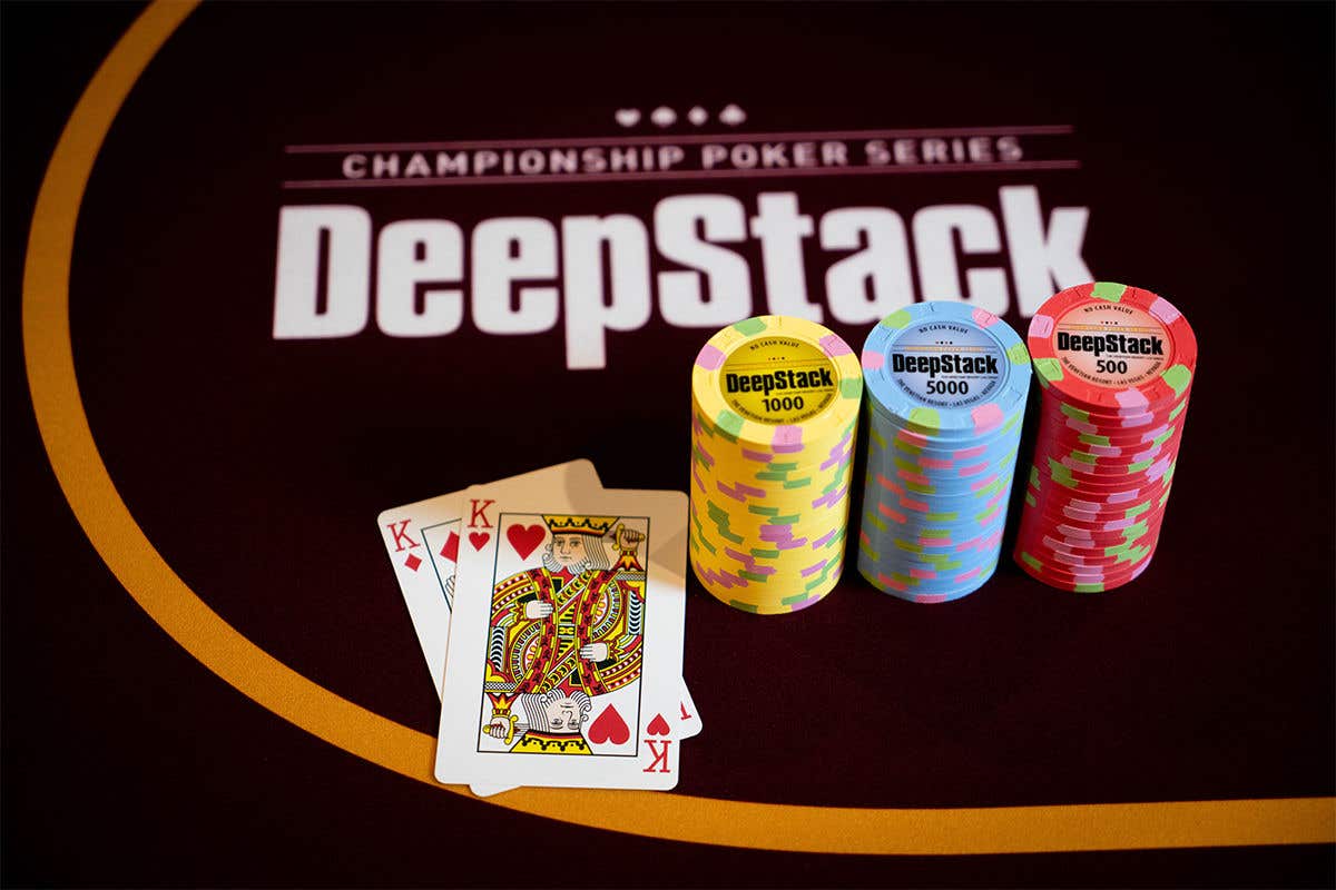 Poker chips and king playing cards on a DeepStack Championship Poker Series poker table.