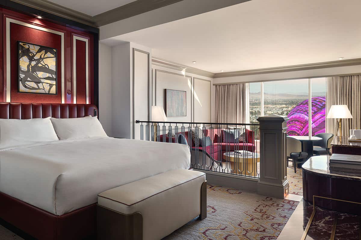 Luxury hotel suite with king bed, living area, and Las Vegas Sphere view.