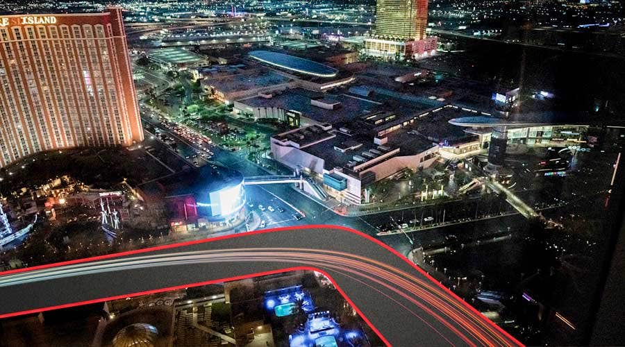Aerial night view of a brightly lit urban cityscape with light trails from moving traffic and illuminated buildings.