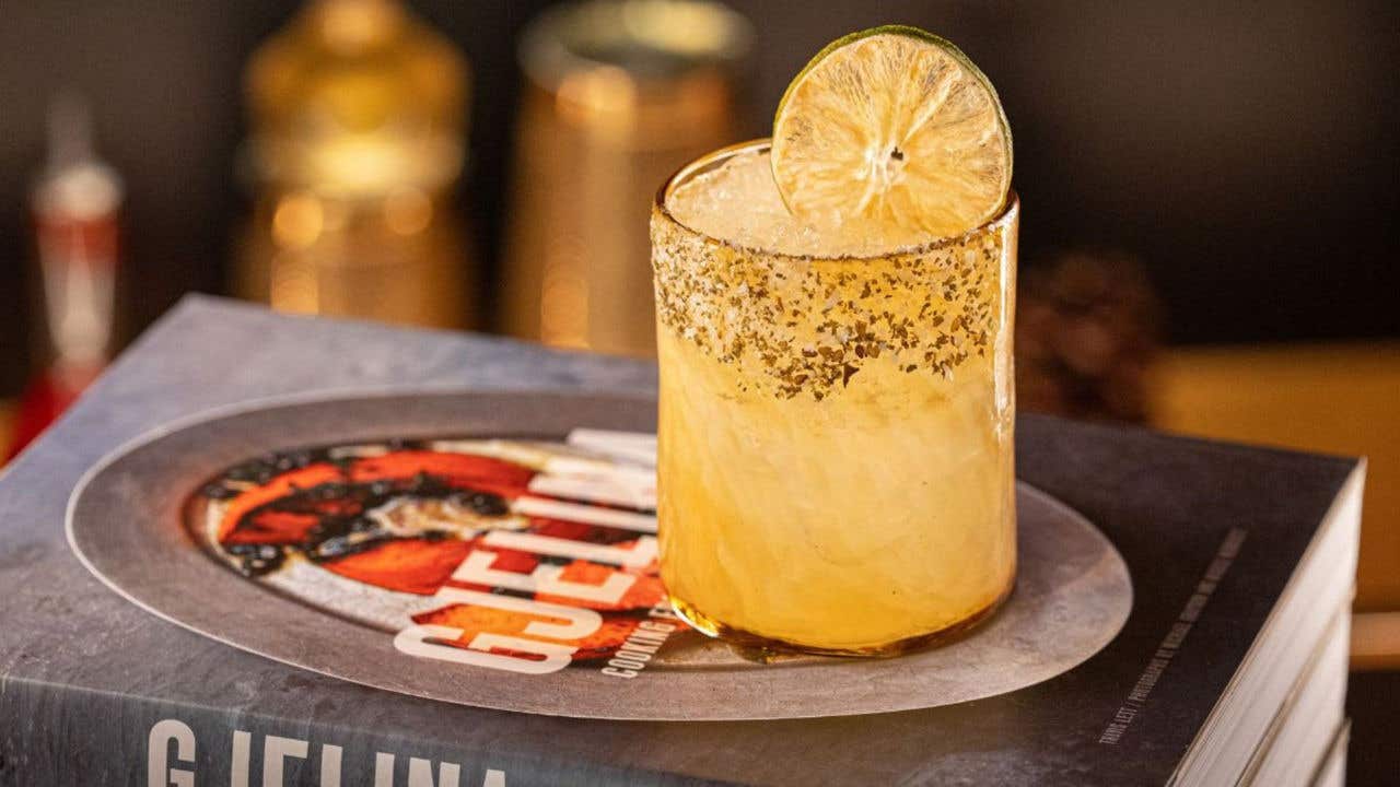 Golden cocktail garnished with dried citrus.