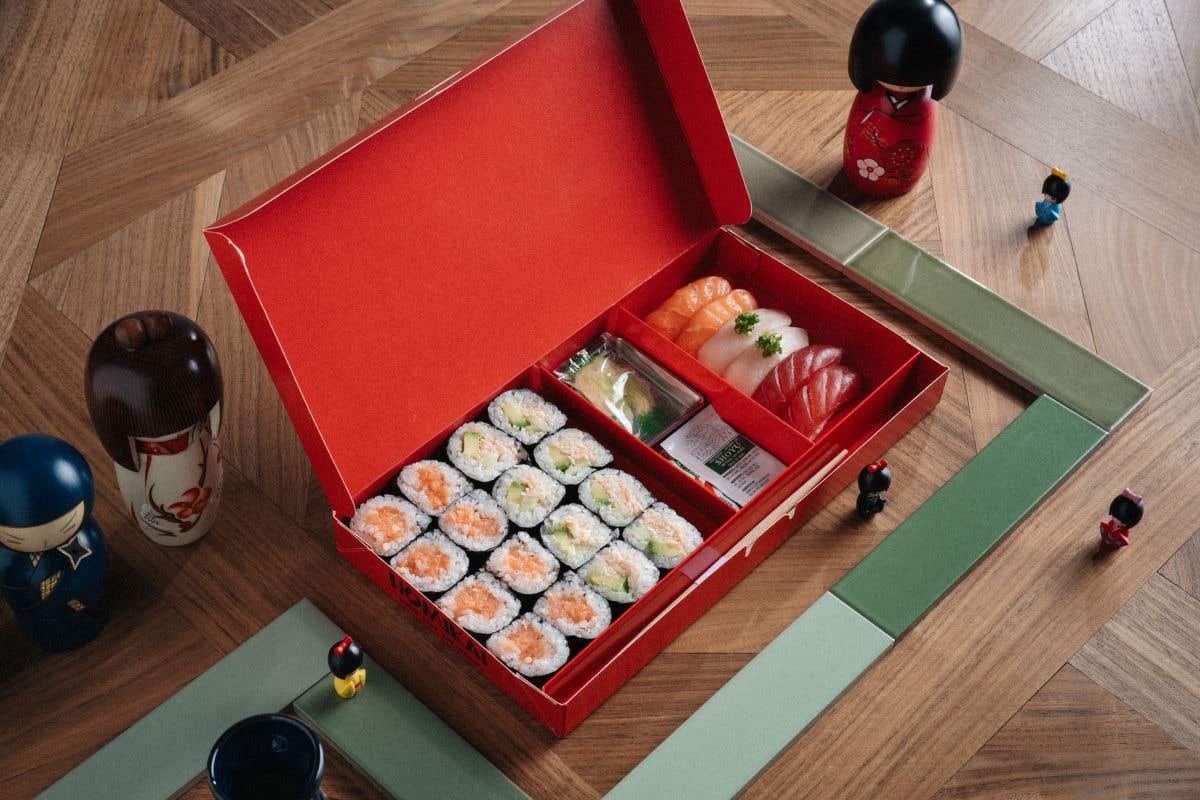 Sushi bento box featuring assorted rolls, nigiri, and traditional accompaniments.