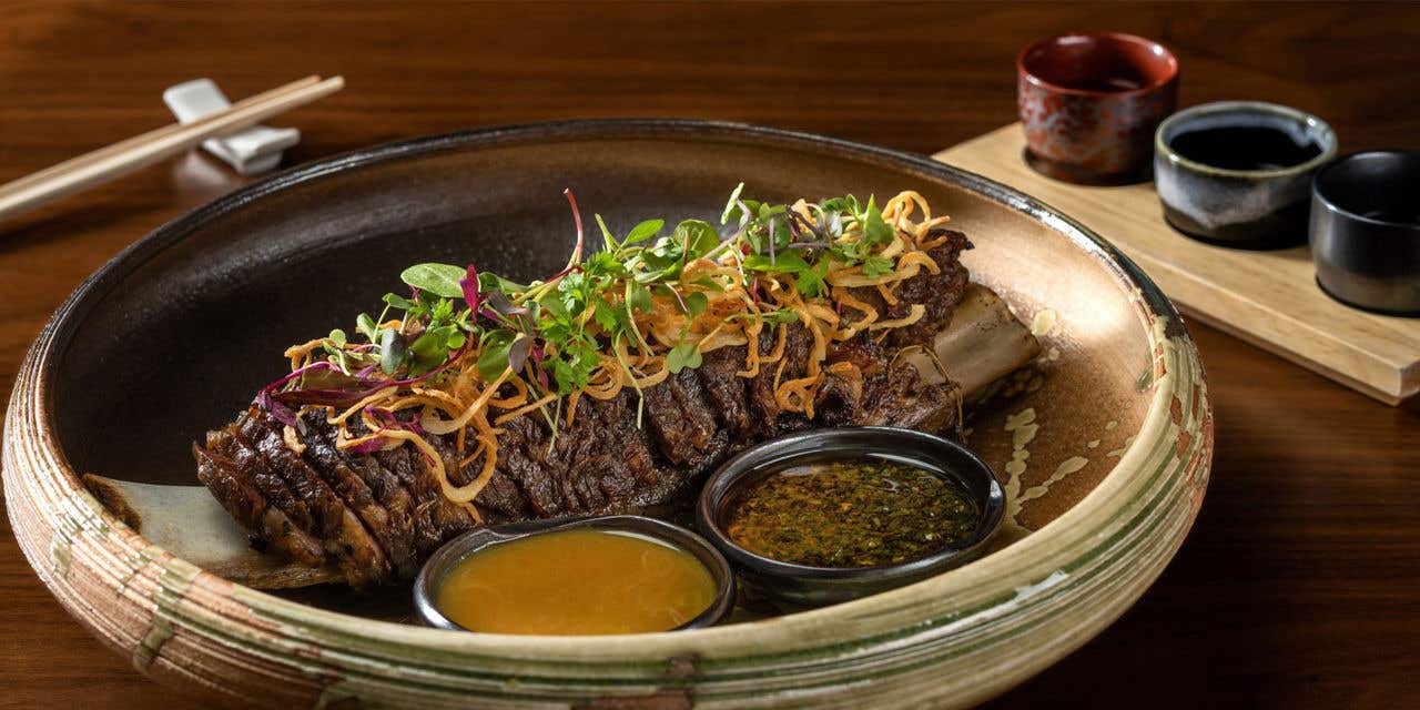 Braised short rib topped with crispy shallots and microgreens, served with dipping sauces.