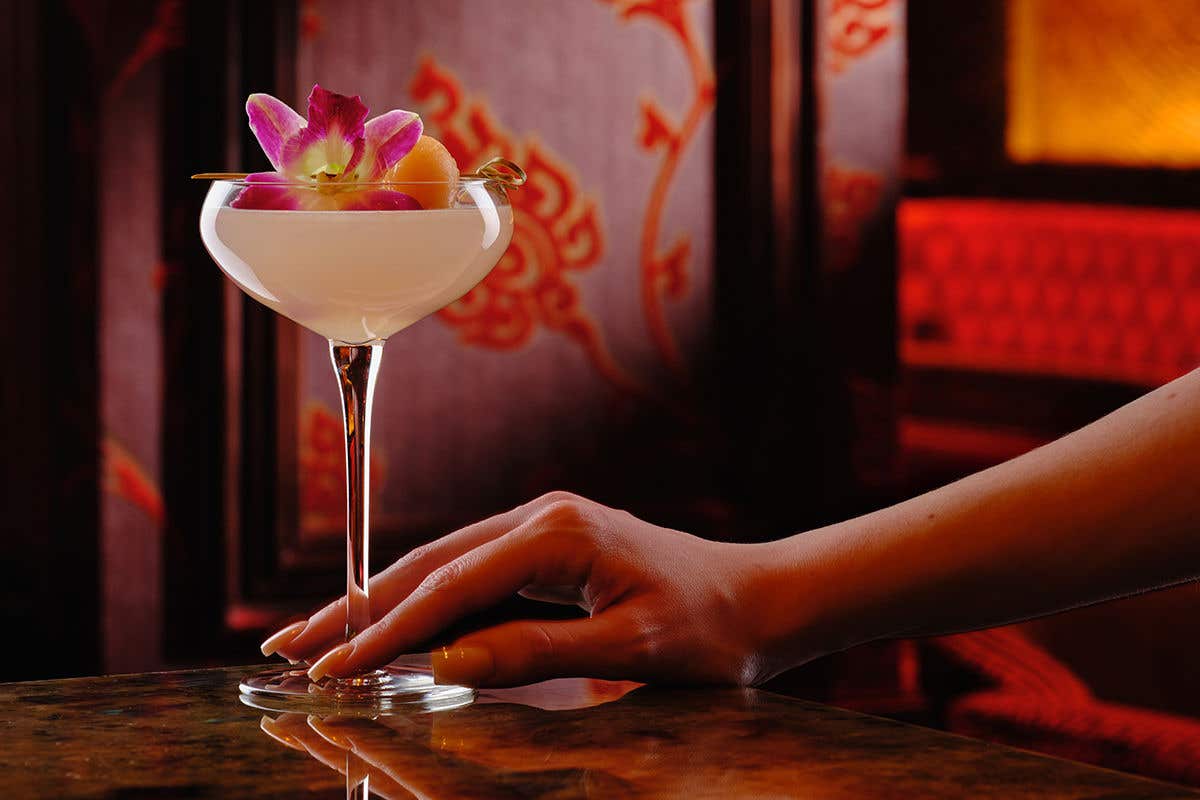 A female handing reaching for the Okami cocktail on a bar at TAO.