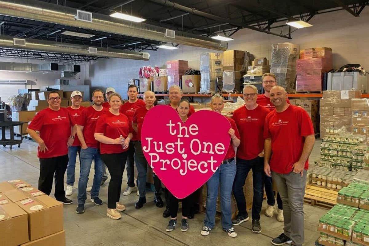 The Just One Project volunteer participants holding a big project sign.
