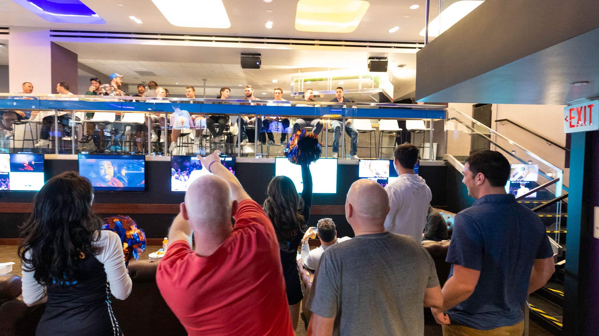 People watching basketball games on different screens cheering.