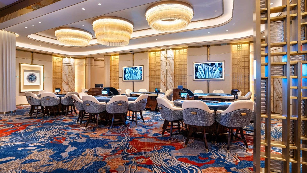 A luxurious casino lounge with tables, chairs, and modern decor.
