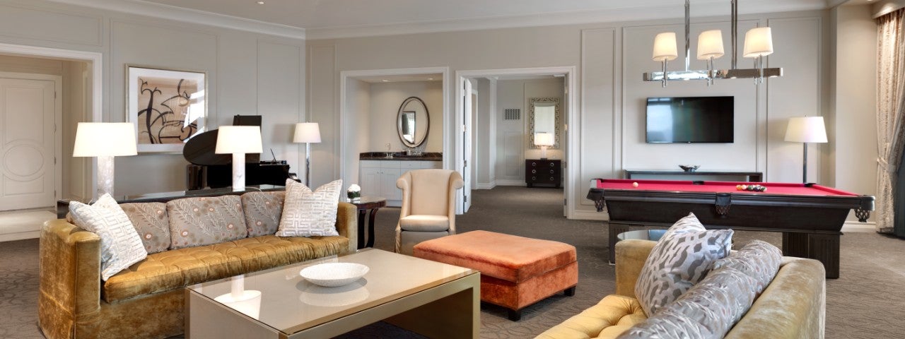 Luxurious living room with sofas, a billiards table, a grand piano, modern decor, and ambient lighting.