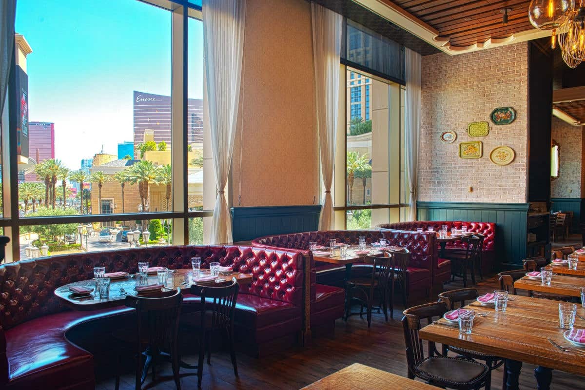Elegant restaurant interior featuring booth seating and large windows with city views.