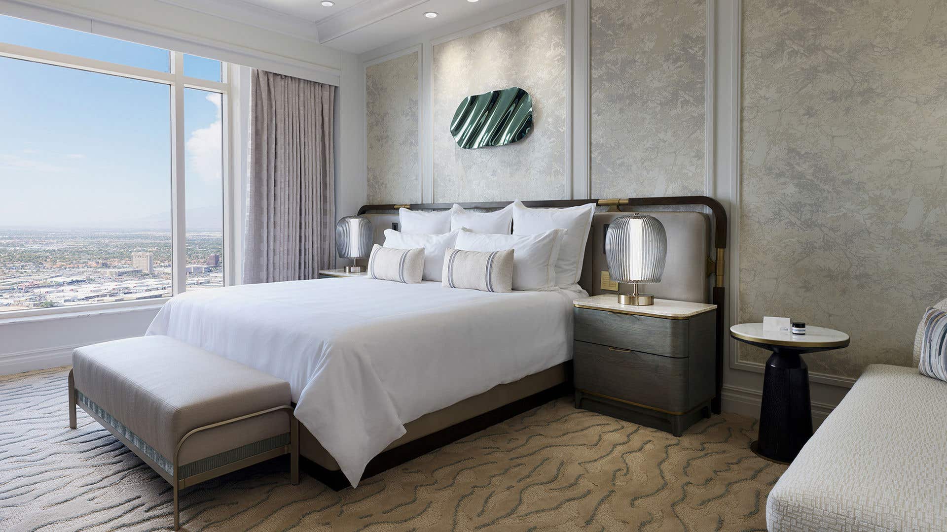 A bedroom in a soft, neutral palette with a view of Las Vegas.