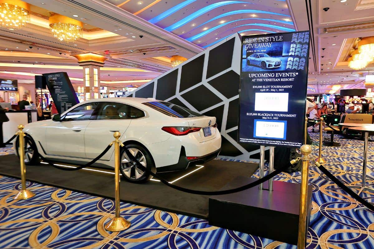 Luxury car giveaway display on casino floor with event signage.