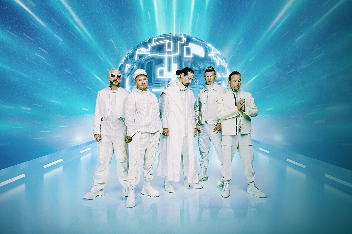 The five members of Backstreet Boys dressed in white on a white reflective floor in a light blue cyber space backdrop