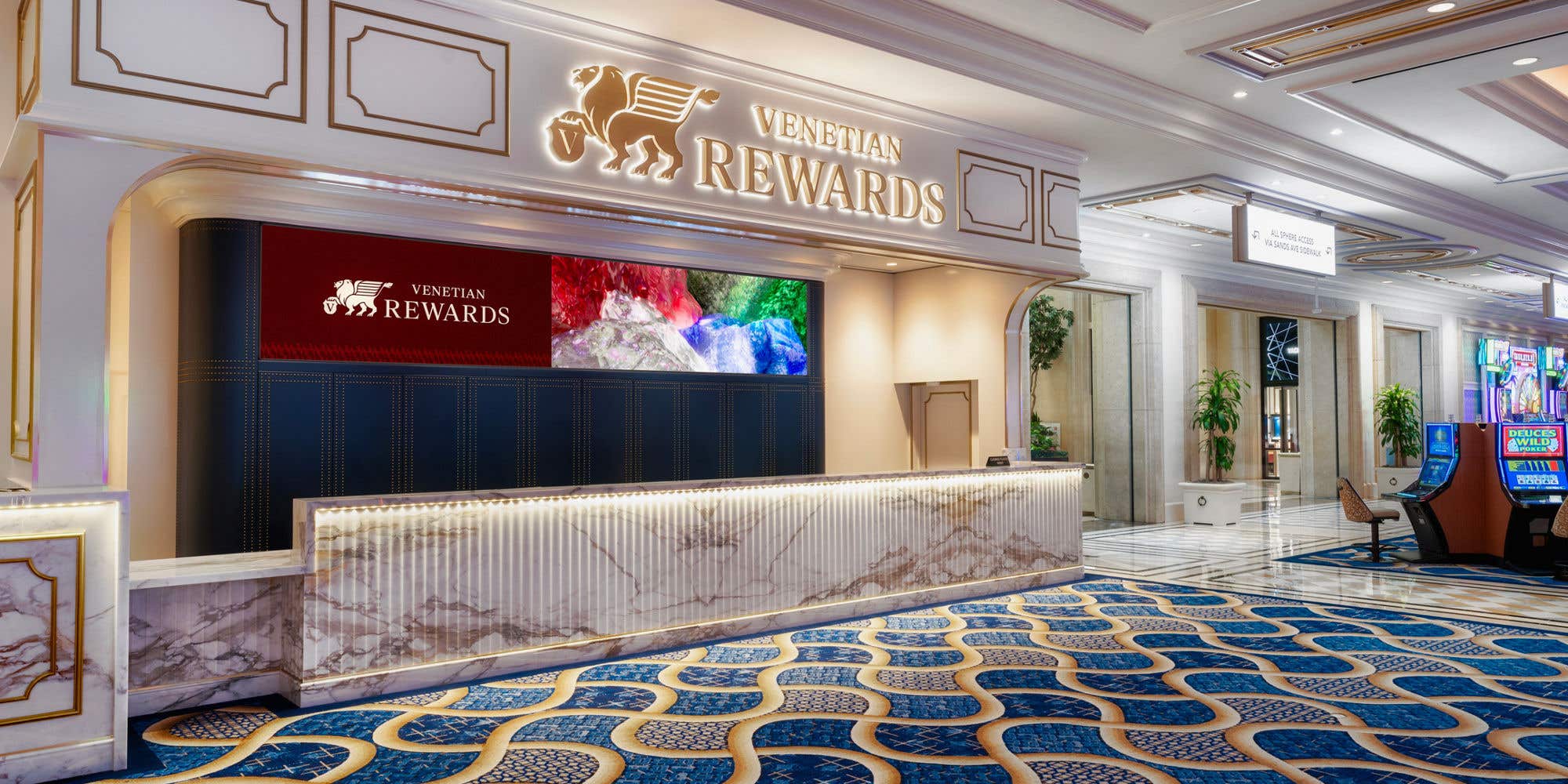 Venetian Rewards desk with illuminated signage in a casino interior.