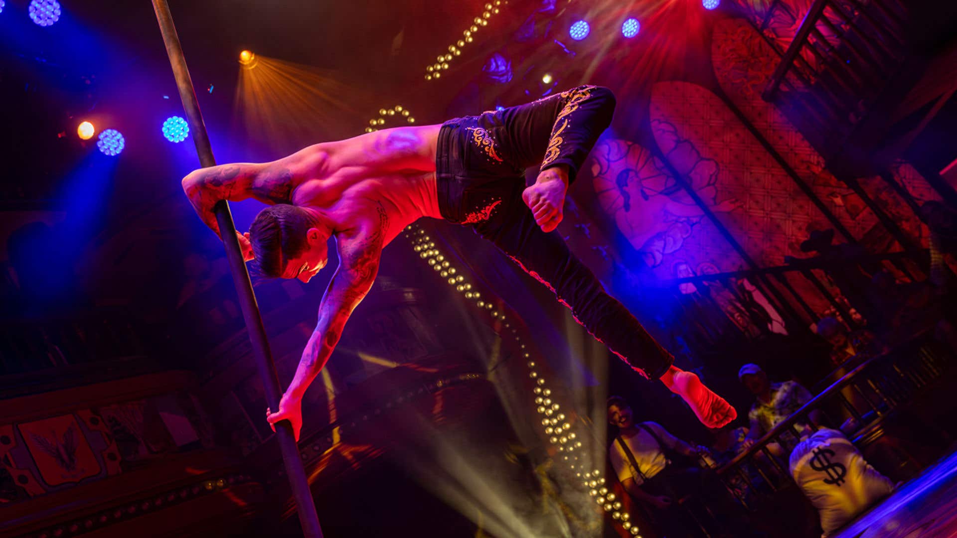 Talent spinning on a pole while performing on stage.