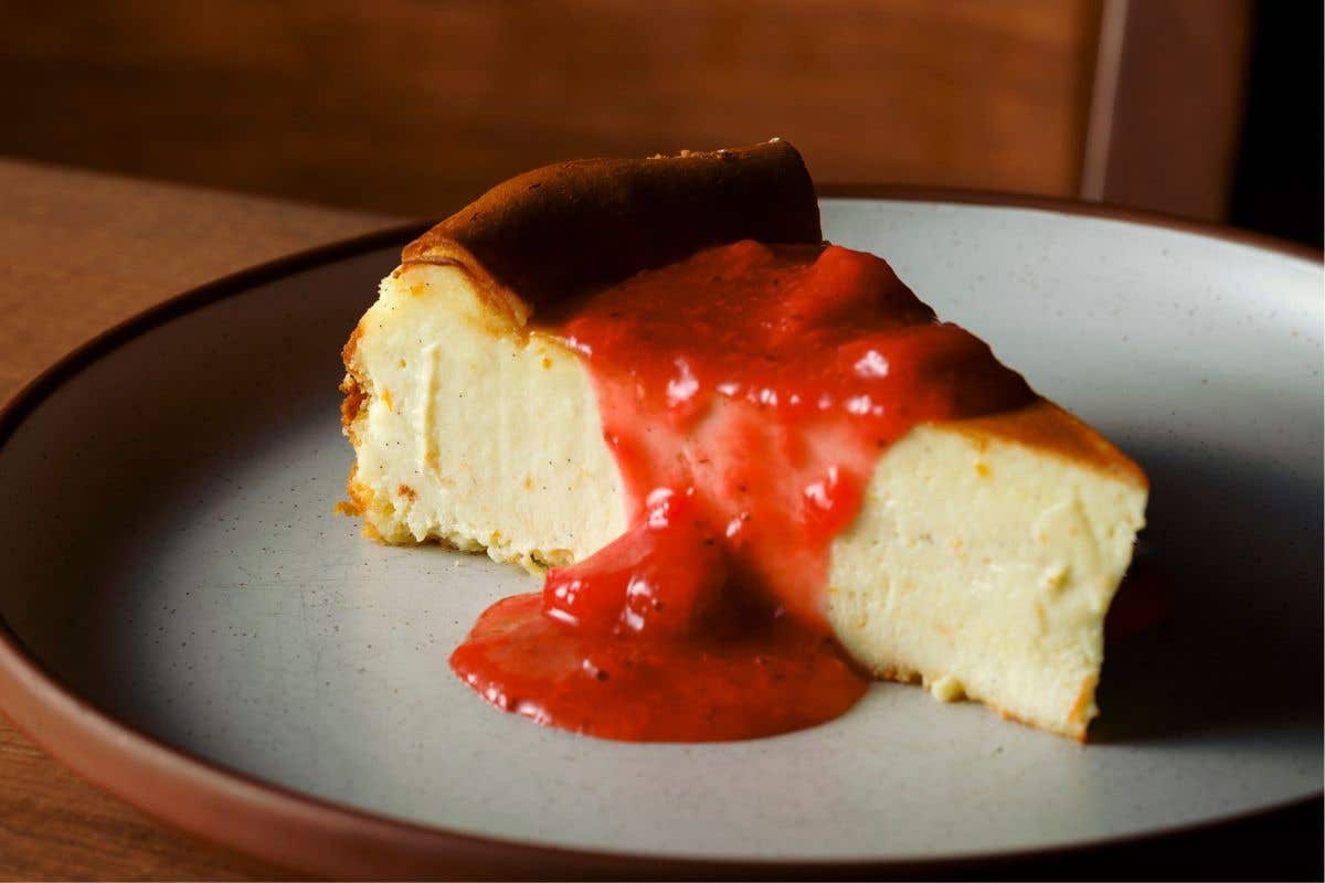 Slice of cheesecake topped with strawberry sauce