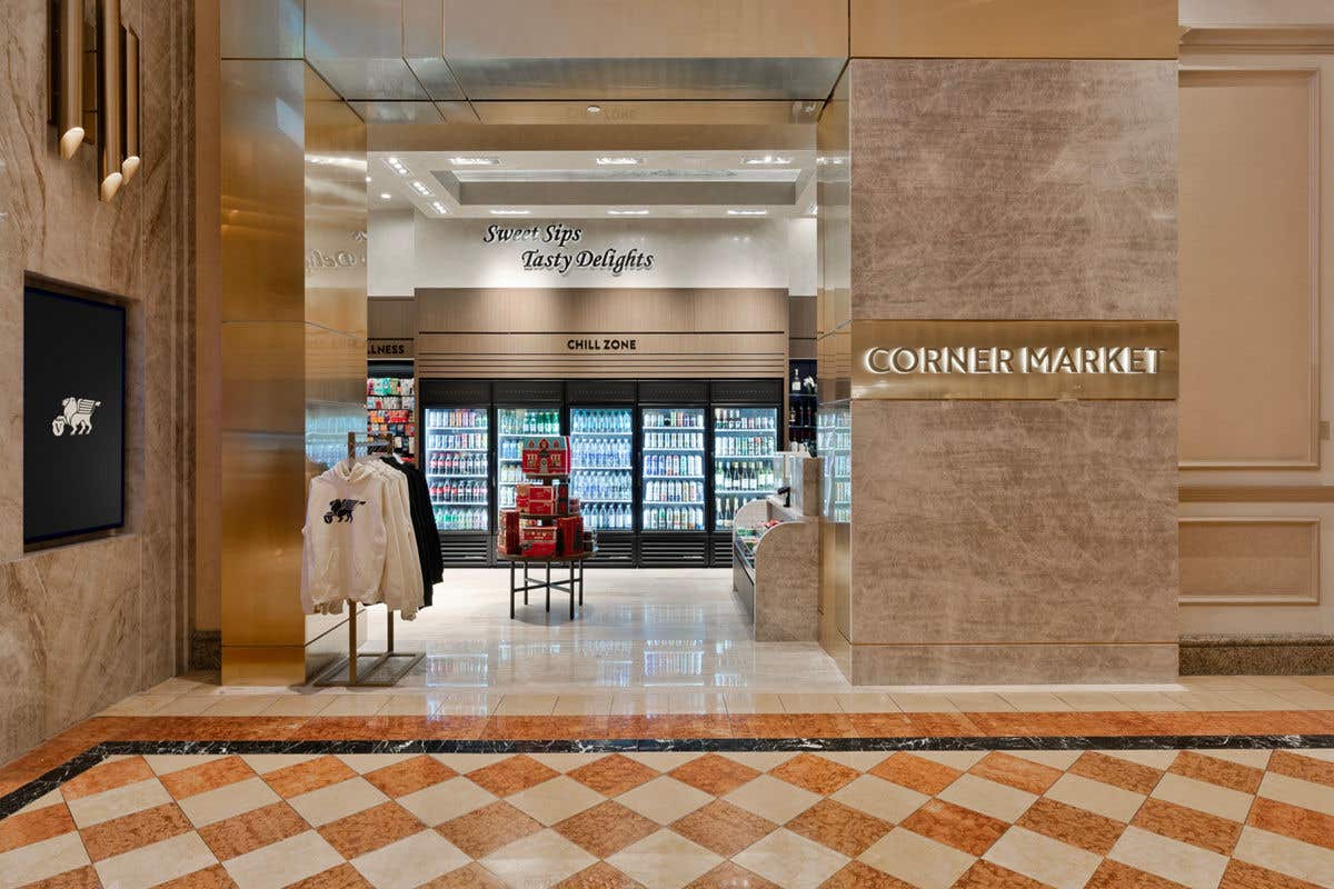 Open gift shop with fridges filled with drinks, clothing racks, and snacks inside.